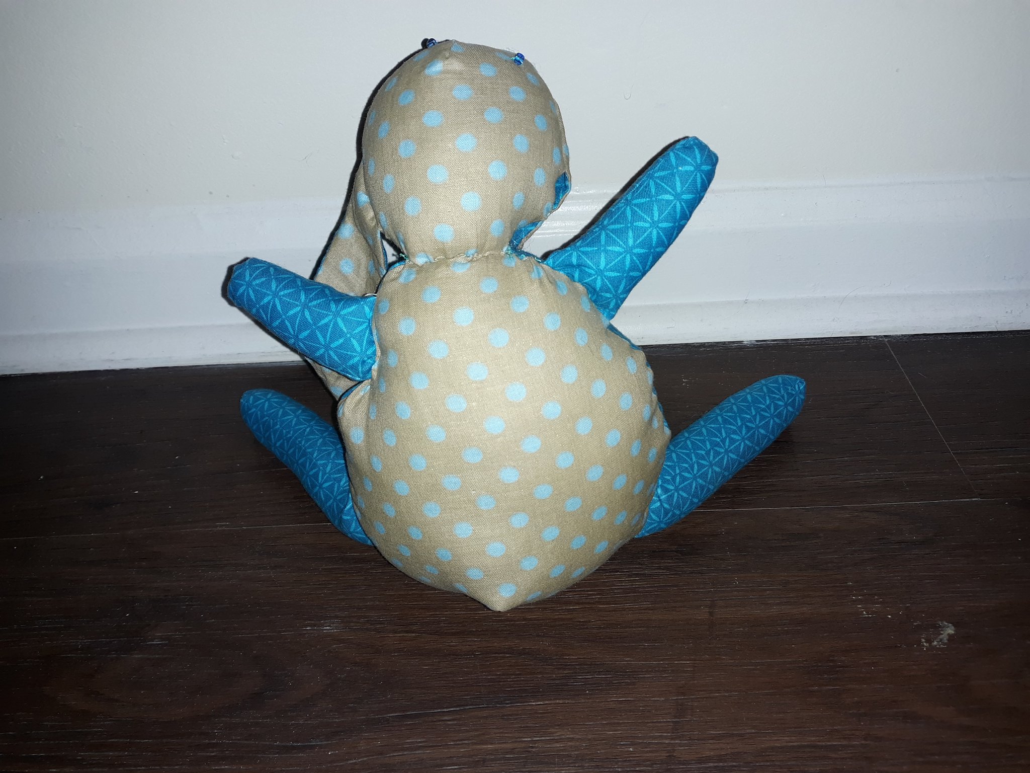 The back of the doll. The back of the body is made of the beige and light blue polka dotted fabric.