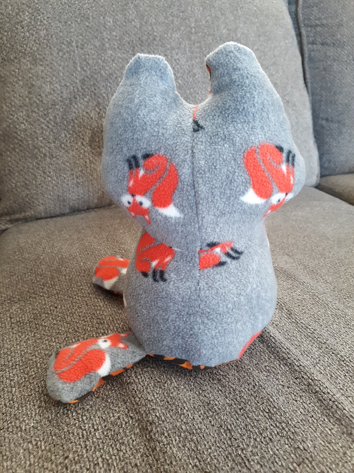 The back of the cat doll. It looks the same as the front, but is lacking a face.