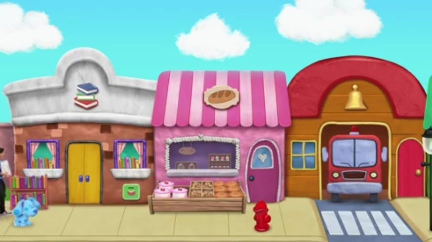 Josh and Blue are in the neighborhood. There are three buildings. The first one is of a library. The second one is of a pink bakery. The third building is of a fire station that has a fire truck inside of it.