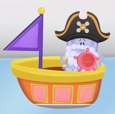 Slippery Soap is standing inside an orange pirate ship that has a purple sail and a red helm floating on water. Slippery has bubbles for a beard and is wearing a black pirate hat.