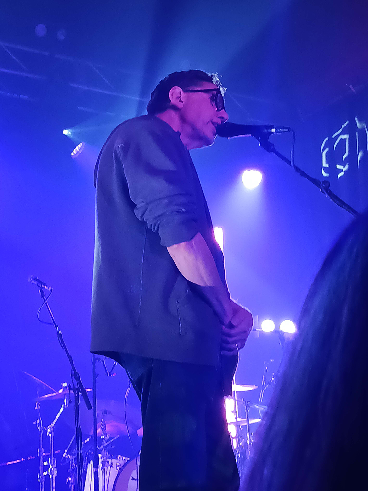 John Linnell on stage singing into a microphone.
