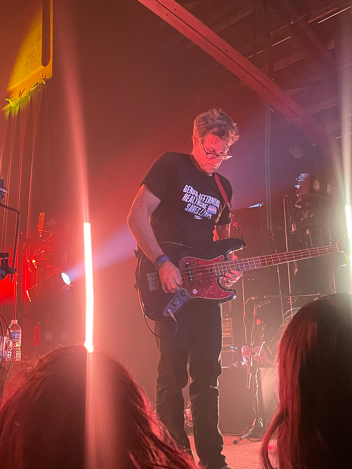 Danny Weinkauf on stage playing a bass guitar.