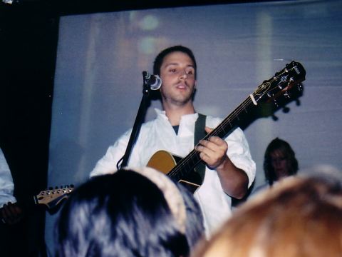 Burns playing his guitar on stage.