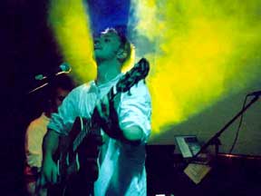 Burns performing on stage with color lights behind him.