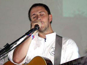 Burns singing into a microphone.