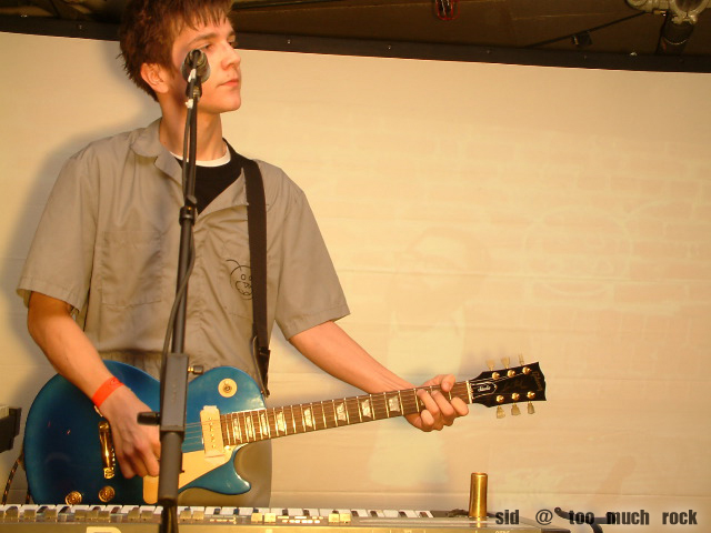 Derek playing guitar on stage.
