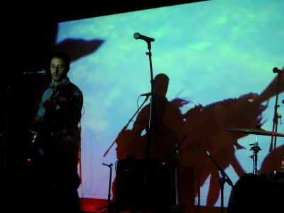 Burns doing sound check while an image is being projected behind him.