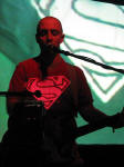 Burns performing with the Superman logo being projected on his shirt.
