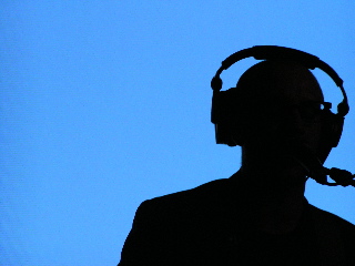 A silhouette of Burns on stage against a blue background.