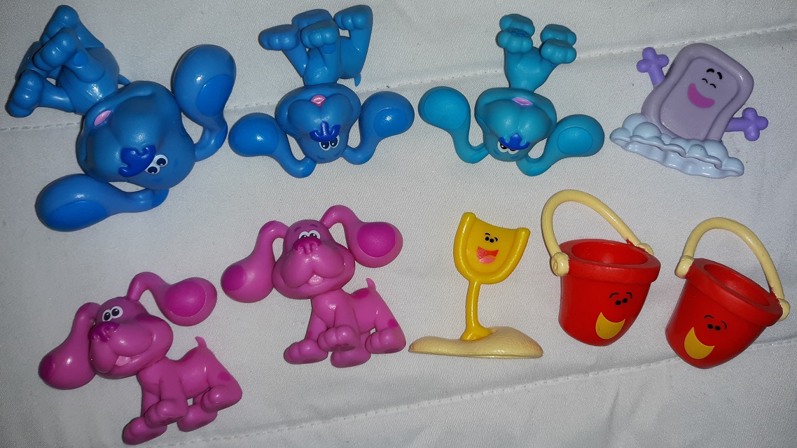 A group of plastic Blue's Clues and You figurines consisting of three Blues, one Slippery Soap, two Magentas, one Shovel, and two Pails.