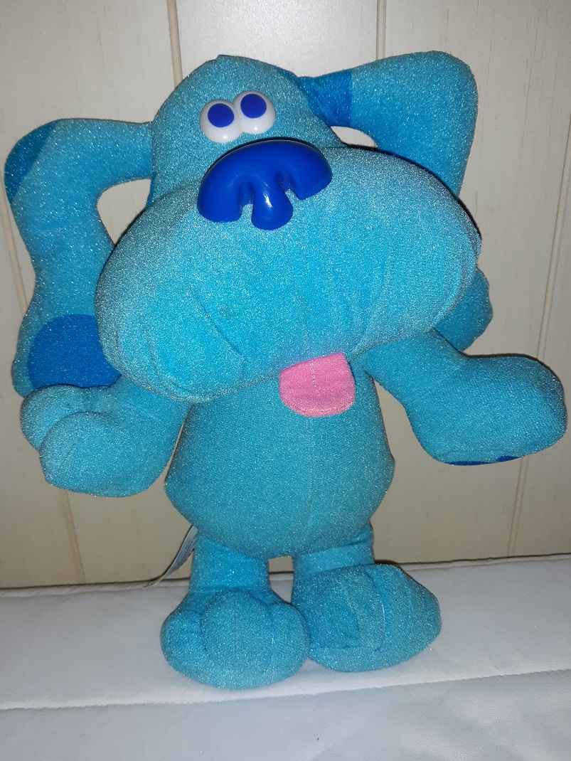 A plush doll of Blue standing up. She has plastic eyes and a plastic nose. Her tongue is sticking out.