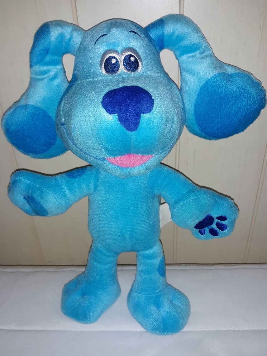 A plush doll of Blue standing up. This one has embroidered eyes with a fabric nose. Her mouth is open in a smile.