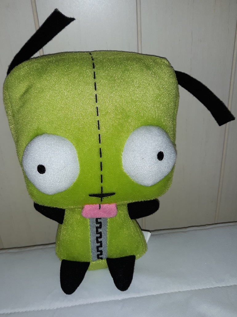 A plush doll of Gir from Invader Zim in his green dog outfit.