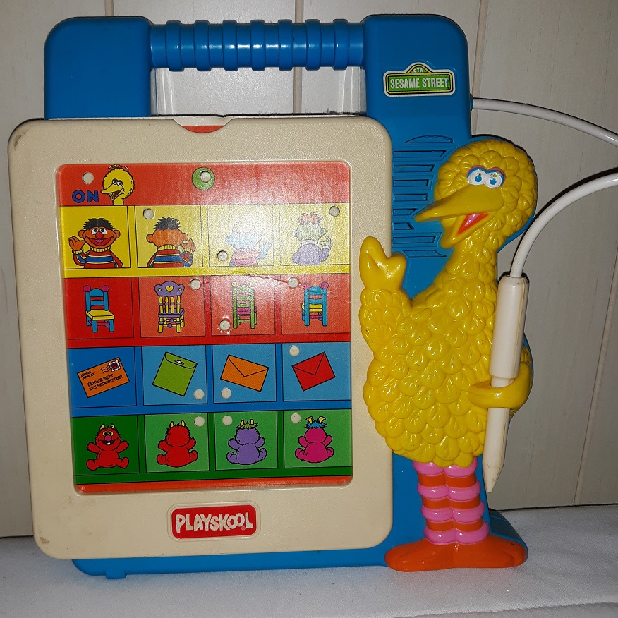 A plastic Sesame Street toy that has cards you put into a slot and press down on the buttons with the stylus that Big Bird is holding.