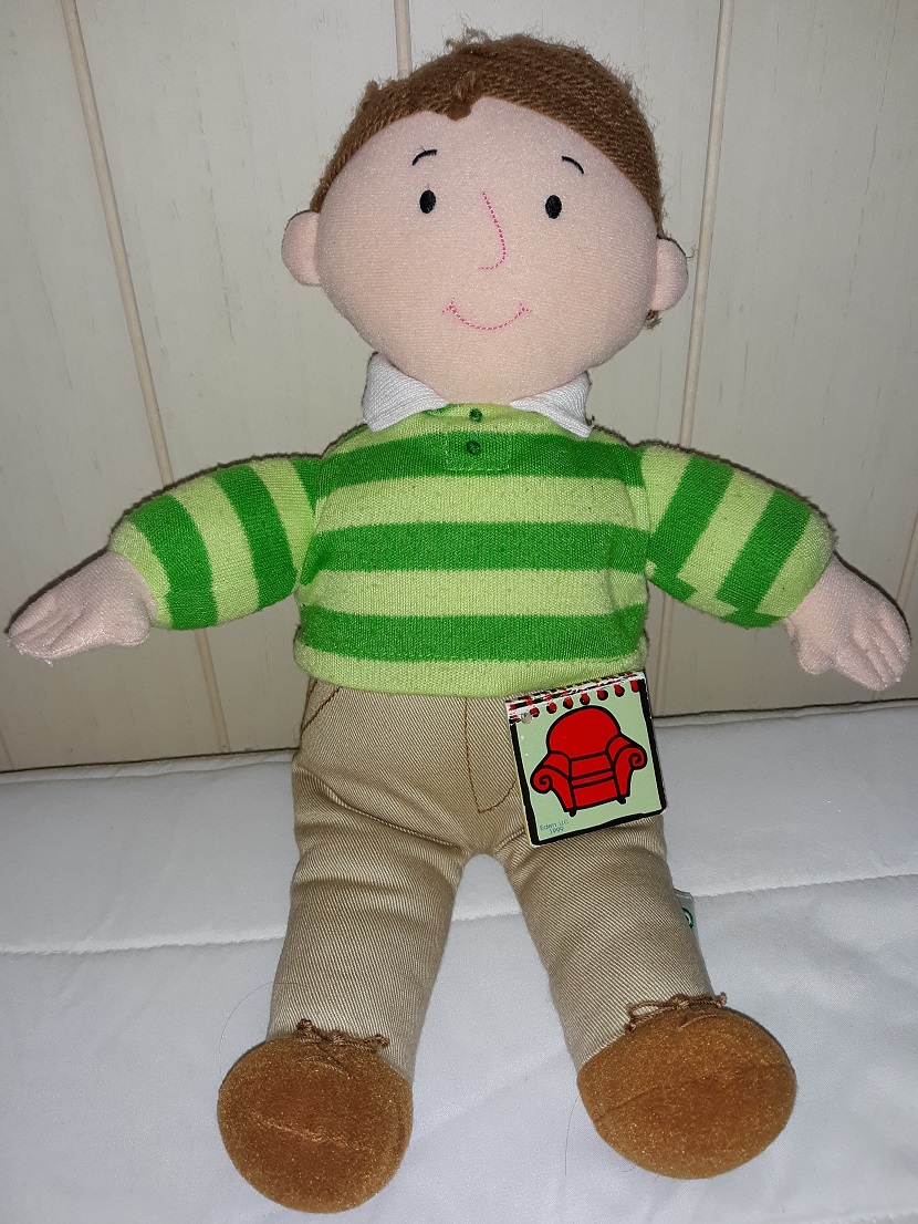 A plush doll of Steve that is all plush with yarn hair and an embroidered face. He has his notebook laying on his leg.