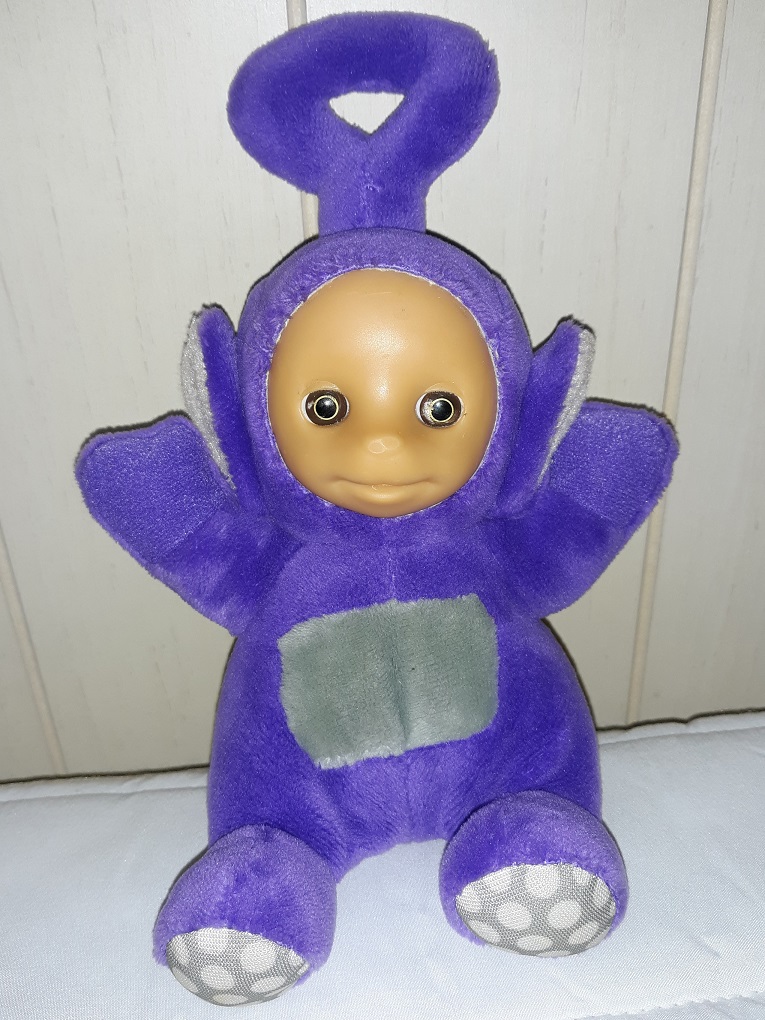 A small plush doll of Tinky Winky from Teletubbies. He has a plastic face.